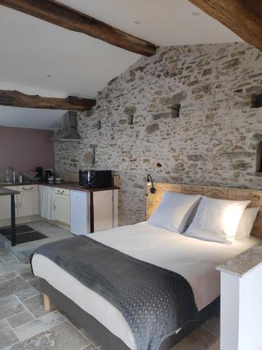 une chambre avec un lit et un mur en pierre dans l'établissement Studio 30m2 La Cave - Les Gîtes du Lac - Proche Nantes, à La Chevrolière