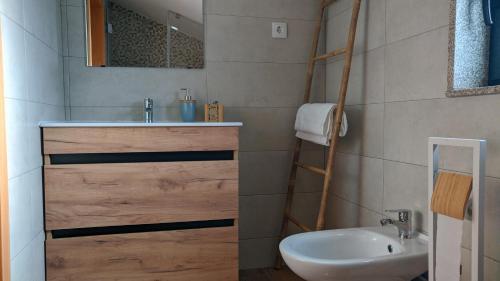a bathroom with a sink and a toilet and a mirror at Casa do Geraço - Douro Guest House in Várzea do Douro