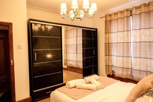 a bedroom with a bed and a window and a chandelier at Spacious 2 Bedroom Flat in London