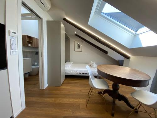 a room with a table and a bed and a skylight at Hostdomus - G10 Suite in Turin