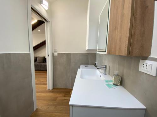 a kitchen with a white sink and white cabinets at Hostdomus - G10 Suite in Turin