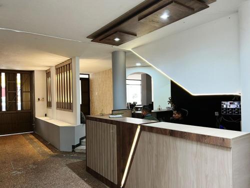 un vestíbulo de oficina con recepción y piano en hotel versalles, en Pasto