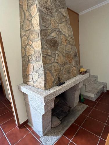 Una chimenea de piedra en una habitación con una pared de piedra. en Casa da Vila - Vilar Maior, Sabugal, en Vilar Maior