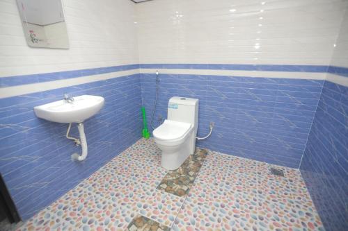 a bathroom with a toilet and a sink at Gilead Holliday in Tāmarakulam