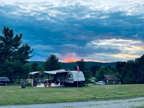 an rv parked in a field with a tent at Lake Lauderdale Campground in Cambridge