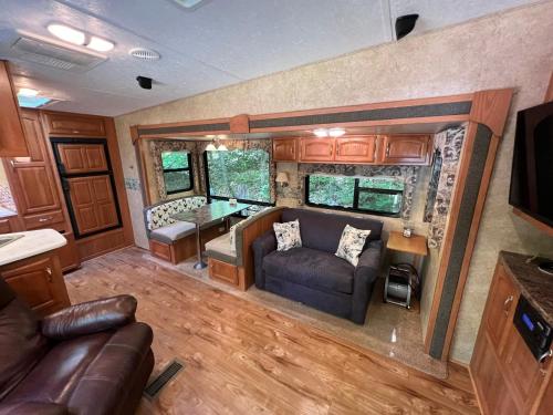an rv living room with a couch and a table at Lake Lauderdale Campground in Cambridge
