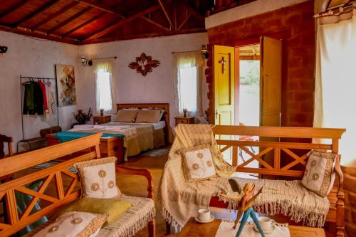 a bedroom with two beds and a table and chairs at Serra a vista Chalé in Prados