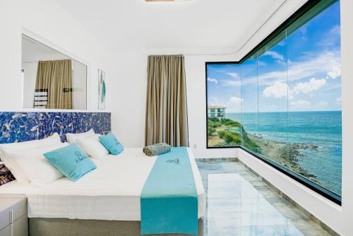 Schlafzimmer mit einem Bett und Meerblick in der Unterkunft condostmaarten by the sea in Koolbaai