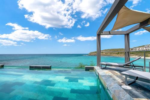 a swimming pool with a view of the ocean at condostmaarten by the sea in Koolbaai