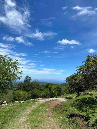 a dirt road on top of a hill with a blue sky at Finca Murillo in Monteverde Costa Rica