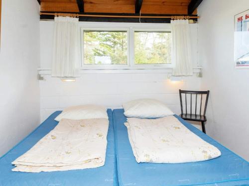 a blue bed in a room with a window at Holiday home Bindslev XXII in Bindslev