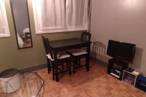 une chambre avec une table, deux chaises et une télévision dans l'établissement Charmant F1 Paris Expo Porte de Versailles, à Vanves