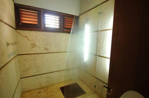 a bathroom with a shower with a toilet and a window at Sunny Vacation Villa No 51 in San Rafael del Yuma