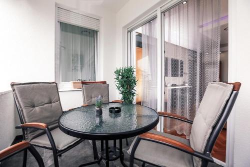 mesa y sillas en una habitación con ventana en Apartman STRONG, en Slavonski Brod