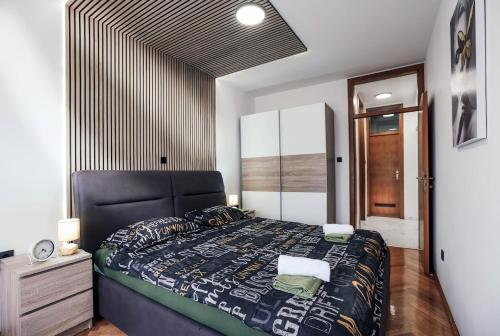 a bedroom with a large bed with a black headboard at Apartman STRONG in Slavonski Brod