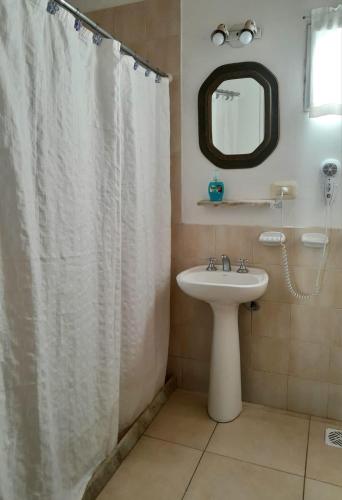 a bathroom with a white shower curtain and a sink at La Candelaria - Casas de Campo - in Sierra de la Ventana