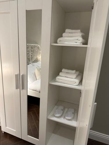 a white closet with white towels and a bed at Apartment Fourty One in Al Khobar