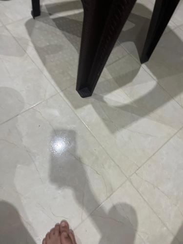 a persons shadow on a tile floor with a persons foot at Anwal in Selouane