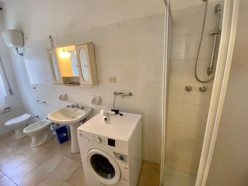 a bathroom with a washing machine and a sink at Appartamento Via Marinedda 9 Isola Rossa in Isola Rossa