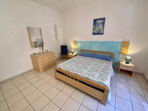 a bedroom with a bed and two tables and a dresser at Appartamento Via Marinedda 9 Isola Rossa in Isola Rossa