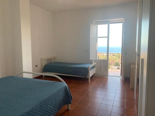 1 Schlafzimmer mit 2 Betten und einer Tür zu einem Balkon in der Unterkunft Casa vacanze Marina di Camerota in Marina di Camerota