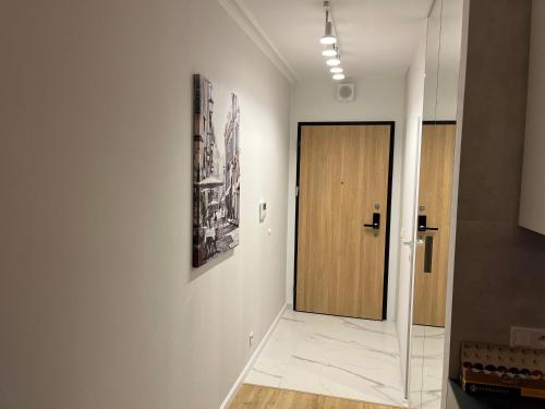 a hallway with a door and a picture on the wall at Warsaw Home Suites in Warsaw