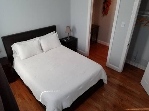 a bed with white sheets and pillows in a bedroom at Wonderful & Cozy Apartment Close to Time Square NYC in North Bergen