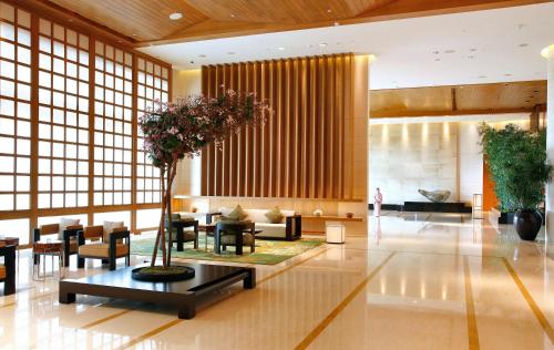 a lobby with a tree in the middle of a building at Hotel Okura Macau in Macau