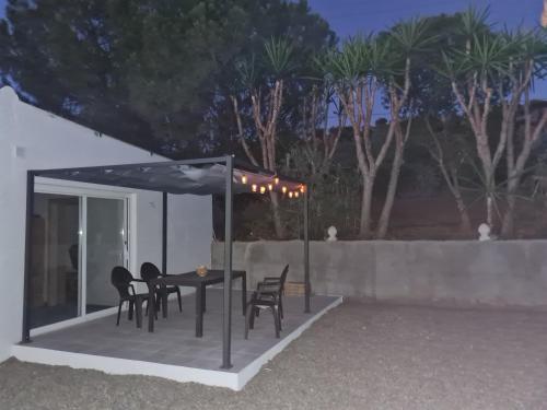 patio con tavolo e sedie sotto ombrellone di Casa Gran Vista de Alora ad Alora