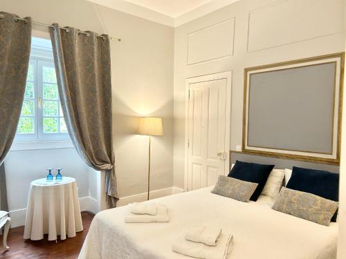 a bedroom with a bed with two towels on it at Villa Branca Jacinta in Sintra