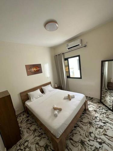 een slaapkamer met een bed met twee knuffels erop bij Appartement neuf/vue sur mer in Yof