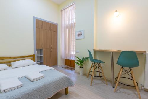 - une chambre avec un lit, un bureau et deux chaises dans l'établissement Lviv Comfort І Затишний Львів, à Lviv