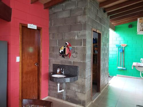 uma casa de banho com um lavatório numa parede de tijolos em Casa para sua família em Bonito