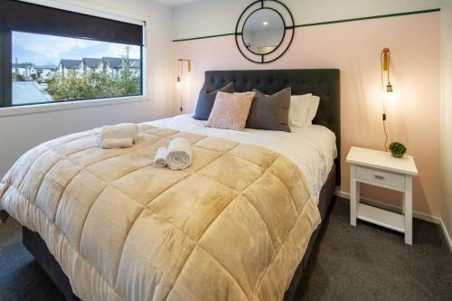 a bedroom with a large bed with a window at Downtown Delight 2 Bed 1 Bath - Single Garage in Christchurch