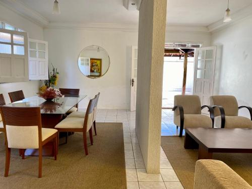 uma sala de jantar com mesa e cadeiras em Kalug - Guest House com 3 quartos em Condomínio na Praia dos Milionários em Ilhéus