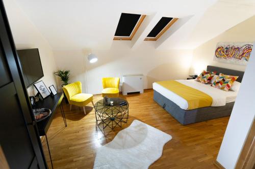 a small room with a bed and a table and chairs at Mini Hotel RiverLux Apartments in Bačka Palanka