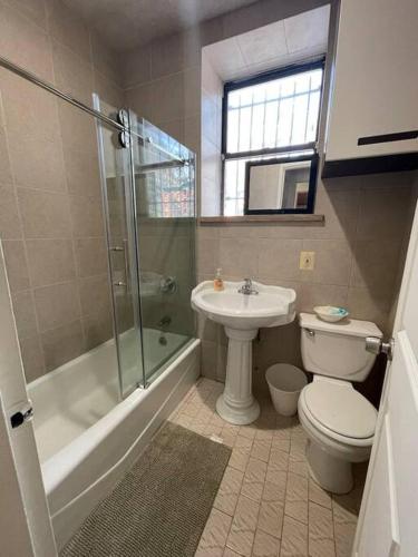 a bathroom with a toilet and a sink and a shower at 2B CLOSe in New York