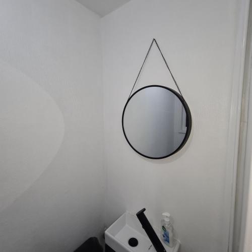a mirror hanging on a wall in a bathroom at Freshen-Up Stays in Oakengates