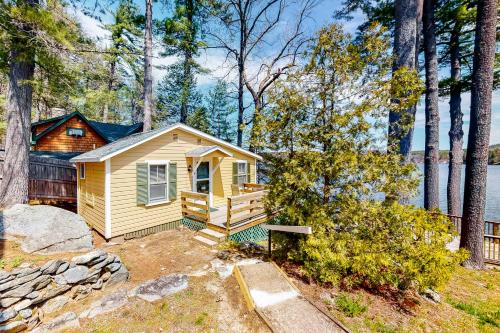 a small yellow cabin in the woods with trees at King Birch Lake Home, Unit 10 in Alton