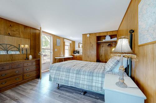 1 dormitorio con 1 cama y 1 mesa con lámpara en King Birch Lake Home, Unit 10, en Alton