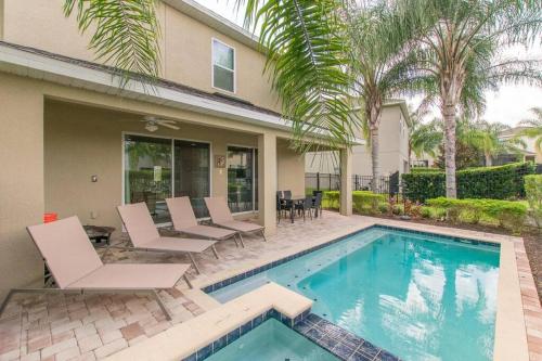 una piscina con sillas y una casa en Luxury 6 BR 6 Bath @Encore Resort Pool Spa Grill., en Orlando