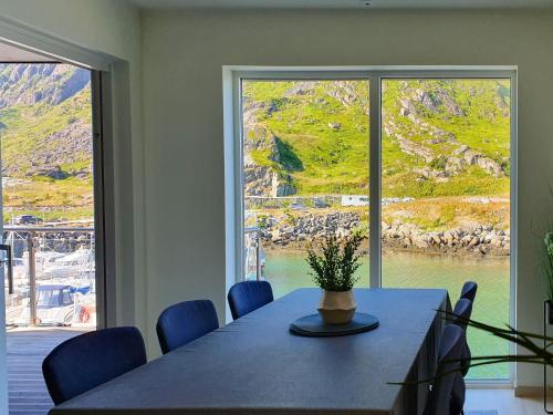 a dining room with a table and a large window at Lofoten Seaside in Ballstad