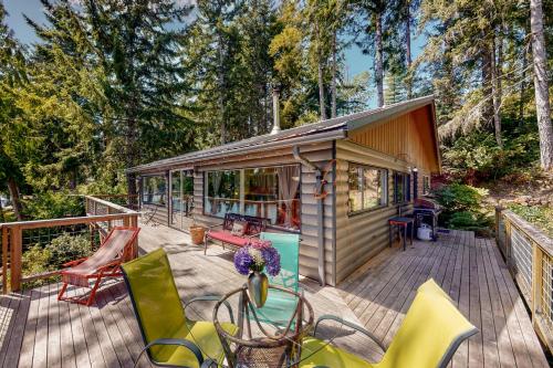 a tiny house on a deck with chairs at Lake Benson Rendezvous in Grapeview