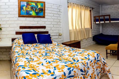 - une chambre avec un lit et des oreillers bleus dans l'établissement Villa Belluno, à Zorritos