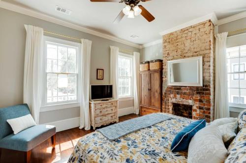 1 dormitorio con chimenea, 1 cama y TV en Historic Savannah Home with Outdoor Grill, Patio en Savannah