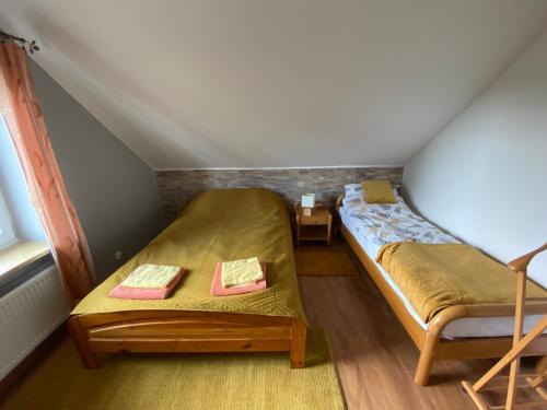 a small room with two beds in a attic at Gospodarstwo Agroturystyczne Zasadkowe Bory in Rogowo
