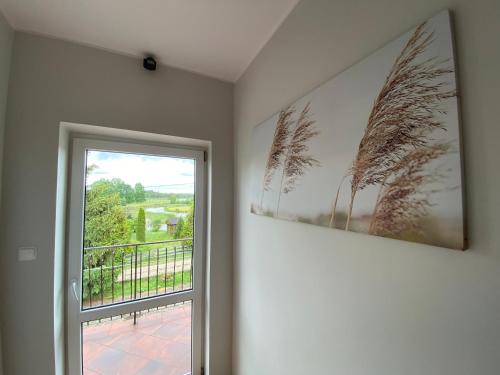 a room with a window and a picture of palm trees at Gospodarstwo Agroturystyczne Zasadkowe Bory in Rogowo