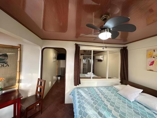 a bedroom with a bed and a ceiling fan at Hotel Brasilito in Brasilito