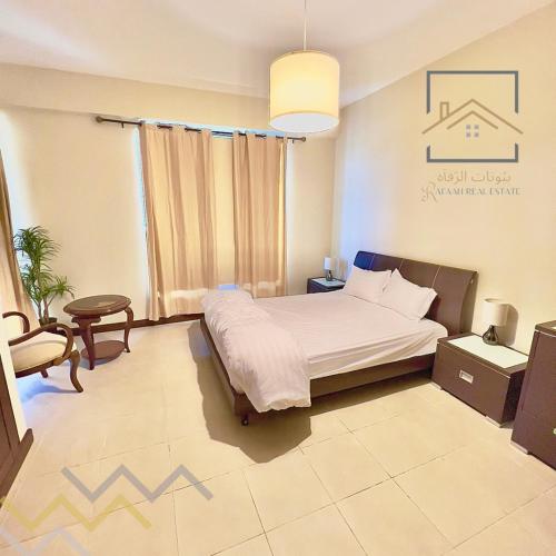 um quarto com uma cama, uma mesa e uma cadeira em بِيُوتات الرفآه - اطلالة بحرية ساحرة em King Abdullah Economic City