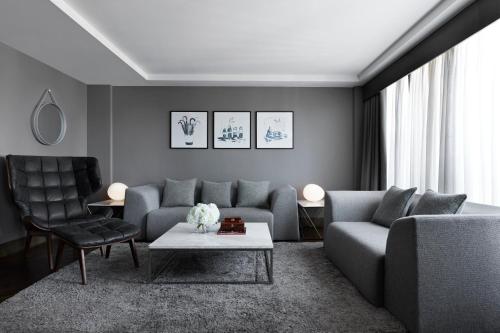 a living room with a couch and a table and chairs at Kimpton Blythswood Square Hotel & Spa by IHG in Glasgow